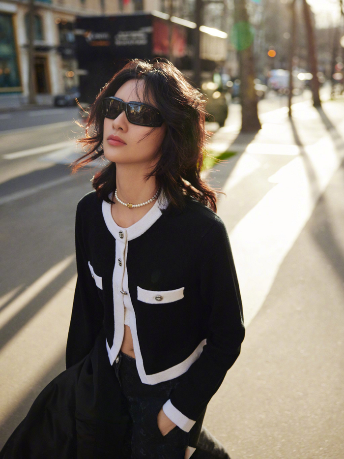 身材高挑的邱天身着黑白针织衫搭配黑色牛仔长裤漫步巴黎街头