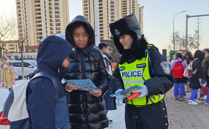 农安县局交警大队民警在农安实验小学护送小学生过马路,站好开学第一