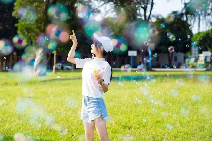 坐在草坪上吹泡泡阳光靓丽美女清新唯美写真