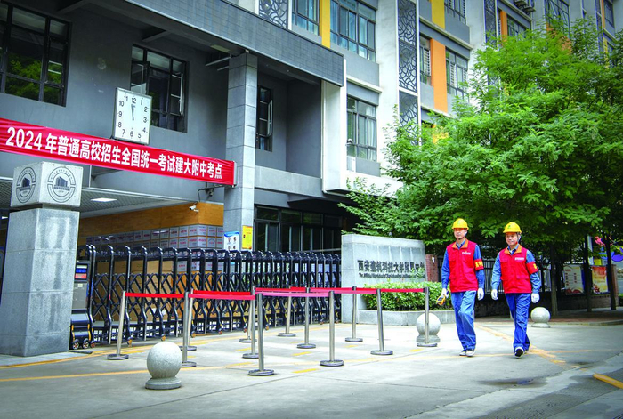 国网西安供电公司工作人员苗凡,苗佳乐正在对建大附中考点电力设备