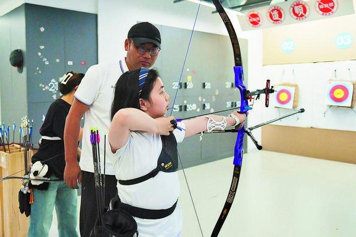 江天漪(中)教练在指导青少年射箭爱好者训练弓箭是最古老的兵器之一