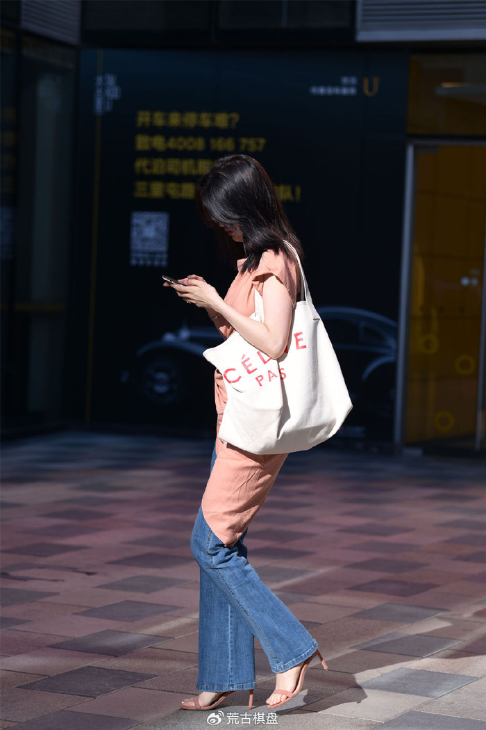 藕荷色的一字带细跟凉鞋,搭配微喇叭牛仔裤,半袖侧衣襟长一些