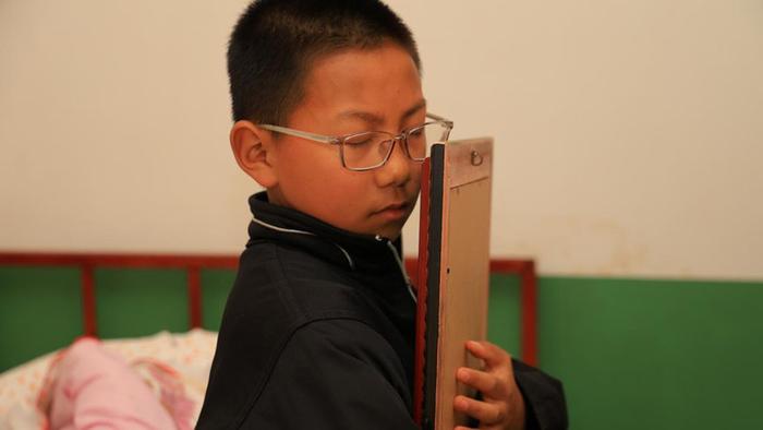 爸爸从高处坠亡，姐弟俩和妈妈相依为命，困境中男童抱着爸爸照片流泪