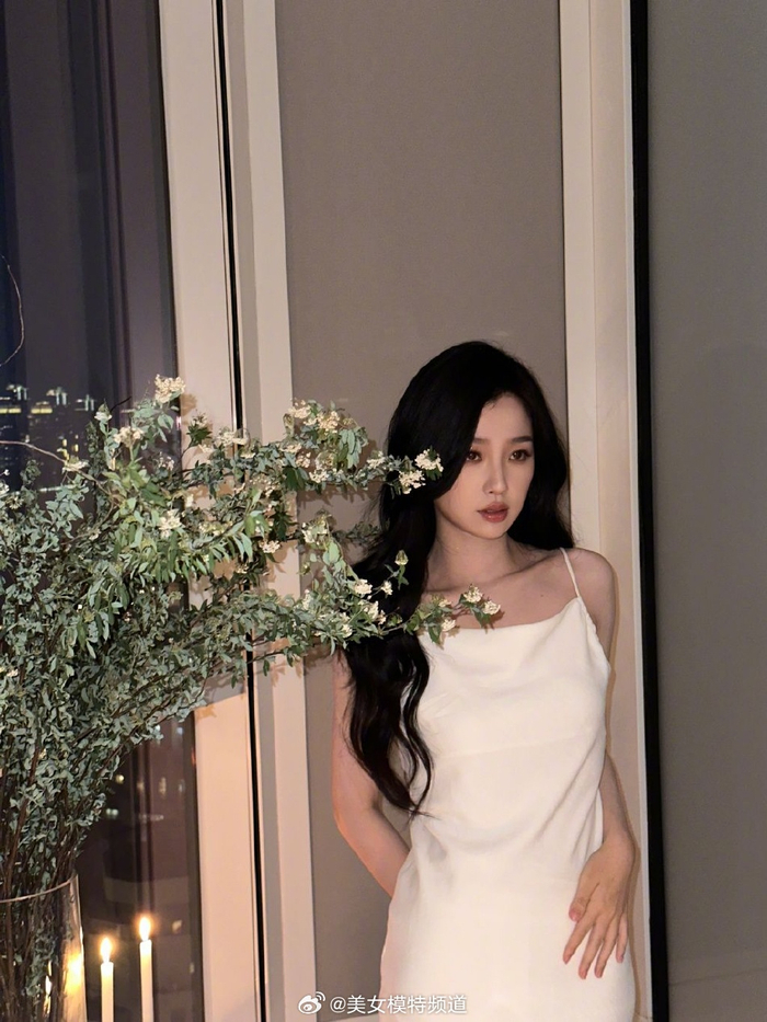 虞书欣穿白色吊带长裙秀美背波浪卷发披肩气质清冷迷人