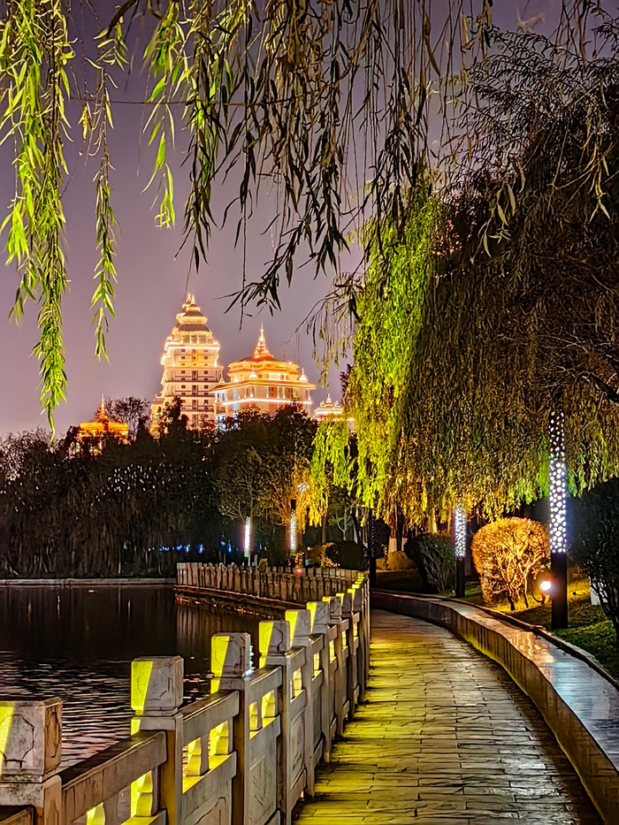 夜色下的临沧玉龙湖,灯光亮起,佤山凤城与锁水阁如梦如幻