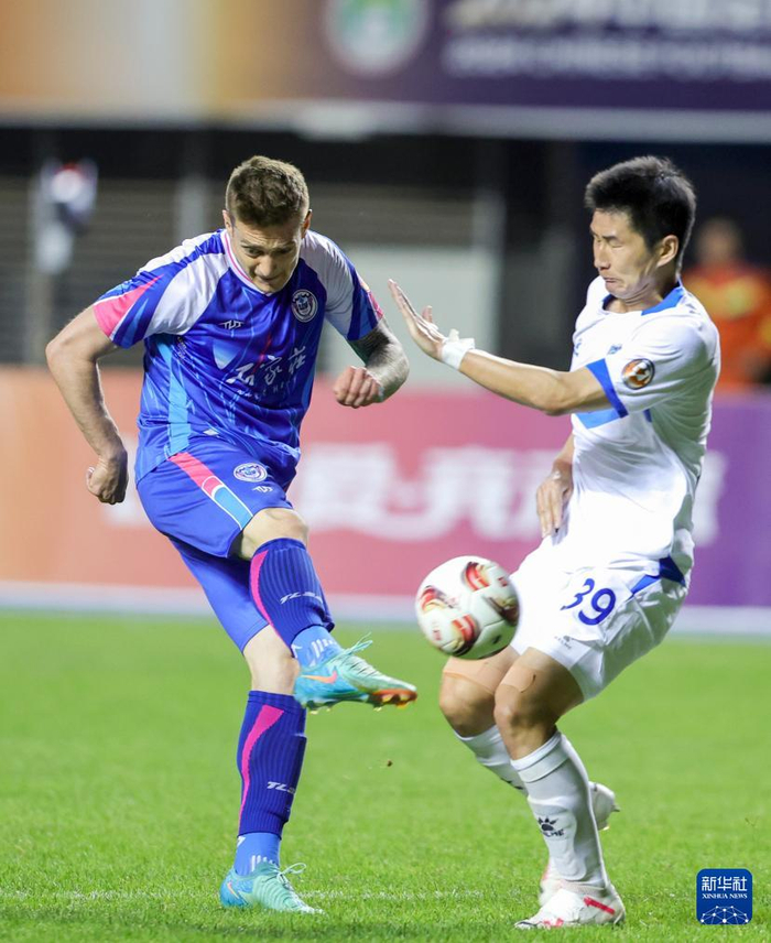 日,石家庄功夫队球员阿约维(左)与佛山南狮队球员张祥硕在比赛中拼抢