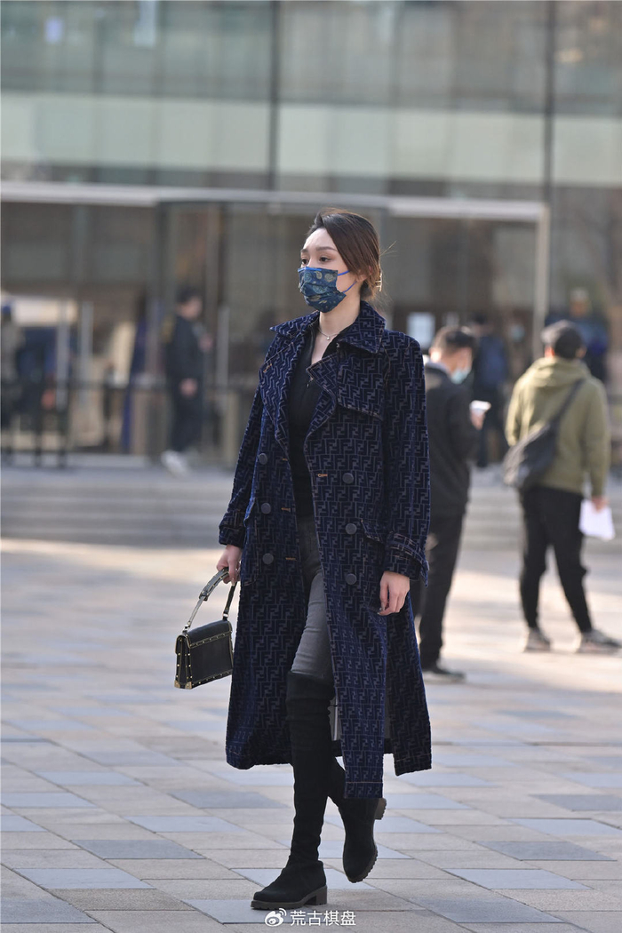 黑色绒面过膝靴,搭配浅灰色的紧身牛仔裤,配合蓝色呢子大衣