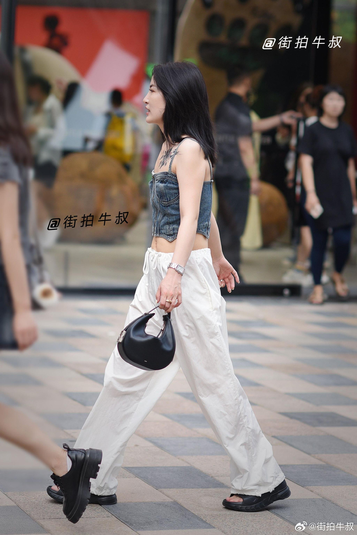 美女拿着时尚的月牙手提包出街