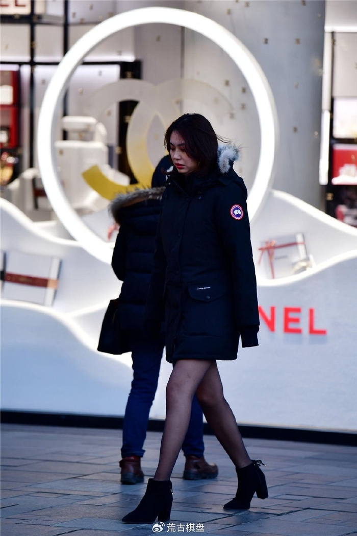 尖头粗跟短靴搭配黑色丝袜美女穿着深蓝色中长款羽绒服