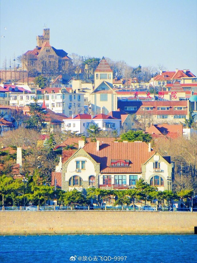 蓝天映衬下的青岛老城区,钟楼耸立,岁月静好