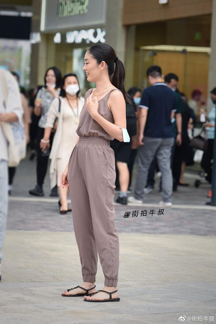 美女穿着好看的紧腰吊带连体裤出街