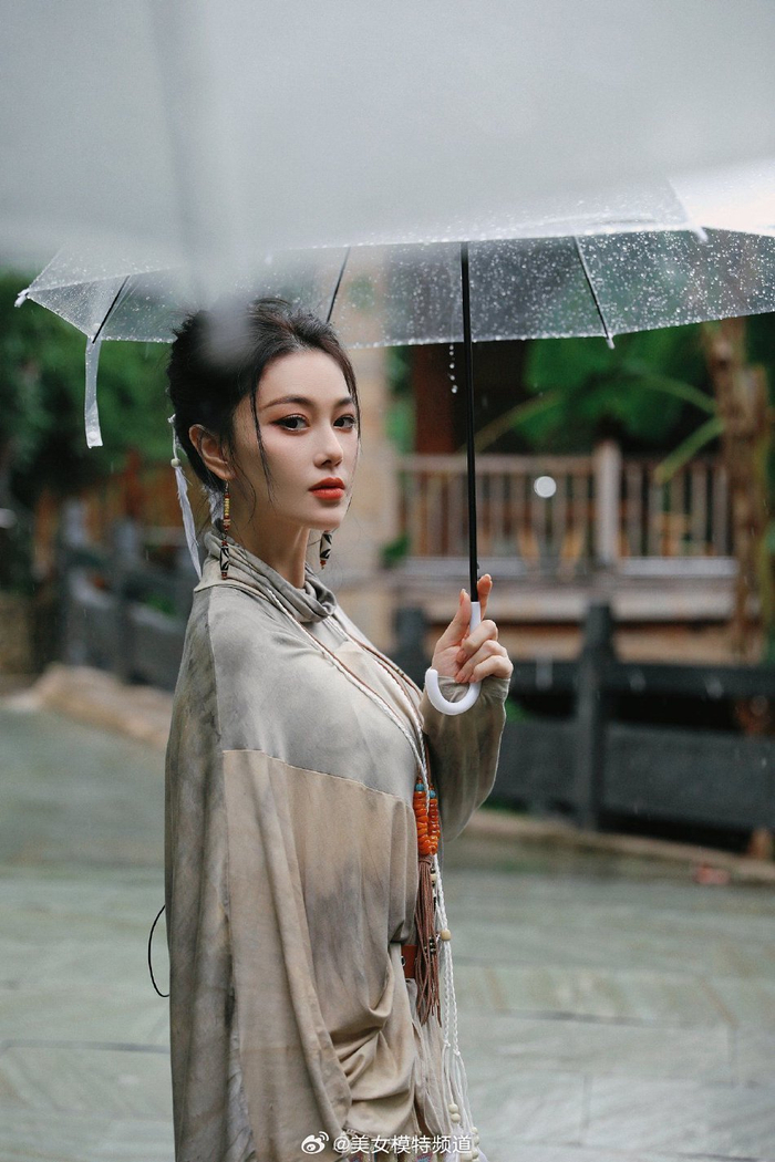 张馨予雨天撑伞写真曝光抬眸看雨五官精致动人