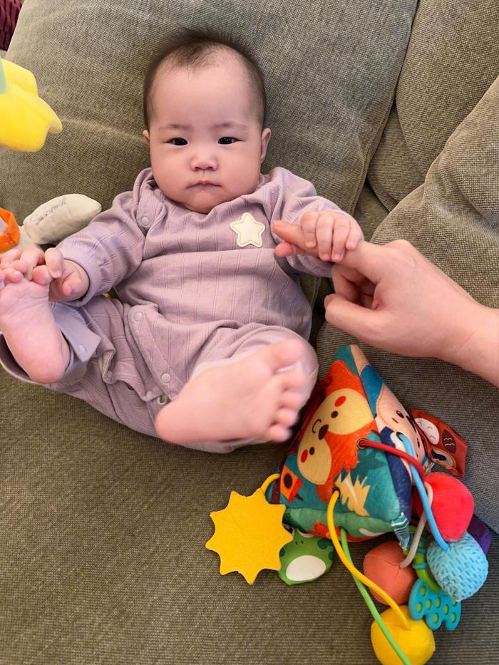 小石榴早上起来在沙发上玩，我坐在她身边