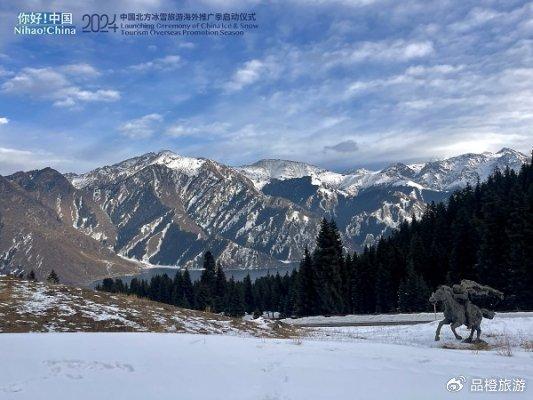 胸前掛著小花帽毛衣鏈,肩上披著艾德萊斯花紋的圍巾,出席啟動儀式的