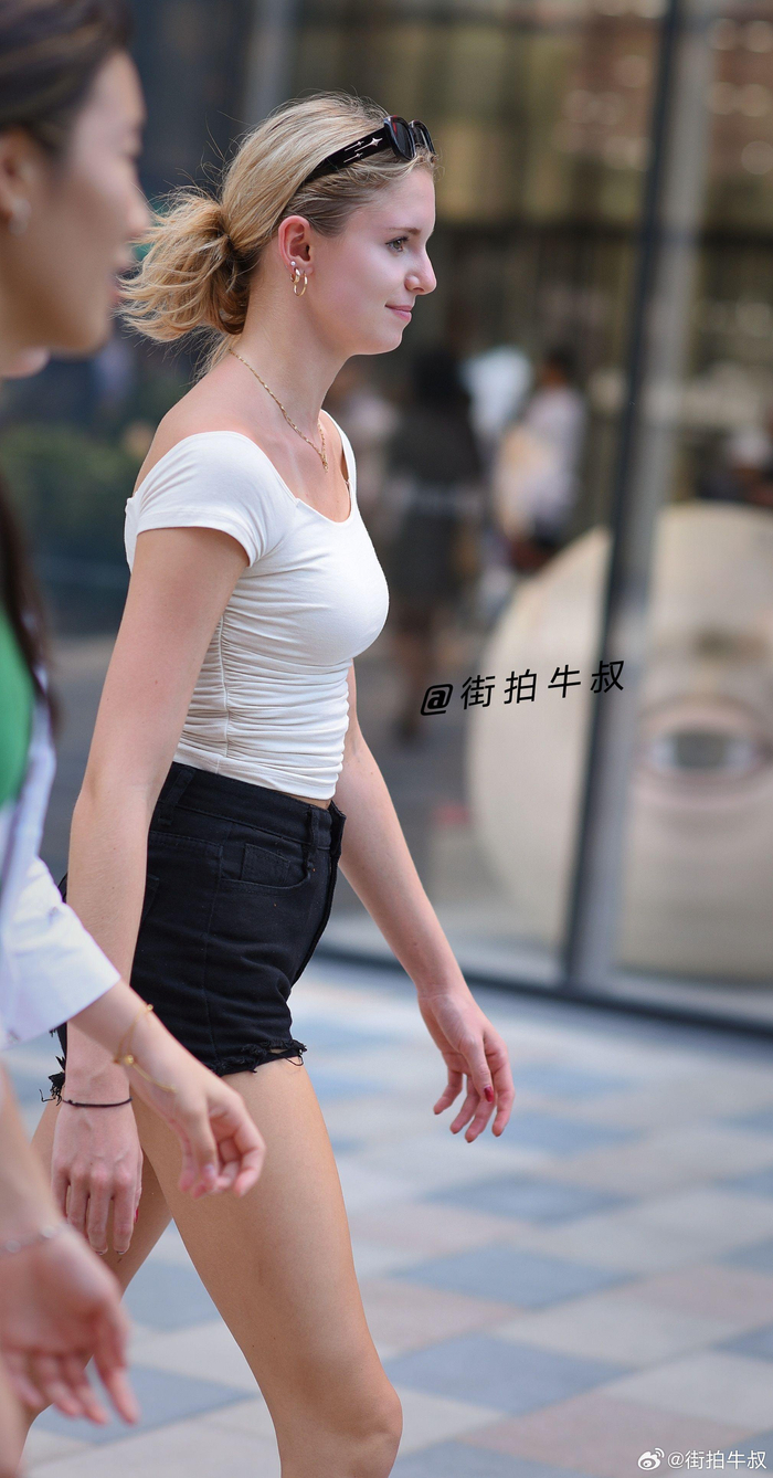 美女穿着黑白色的热裤背心出街