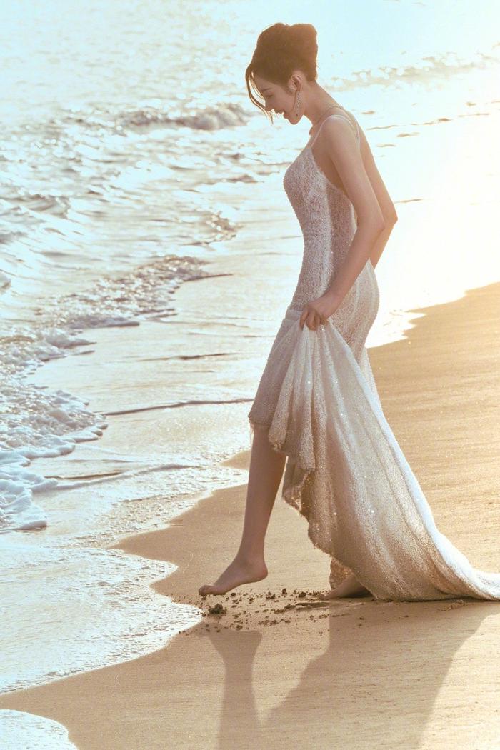 张天爱晒海边沙滩照慵懒风盘发77蕾丝吊带裙在日光下闪闪发光