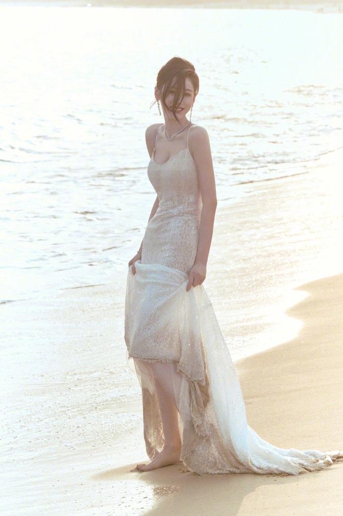 张天爱晒海边沙滩照慵懒风盘发77蕾丝吊带裙在日光下闪闪发光
