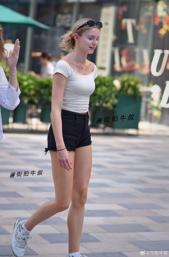 长腿美女穿着热裤背心出街