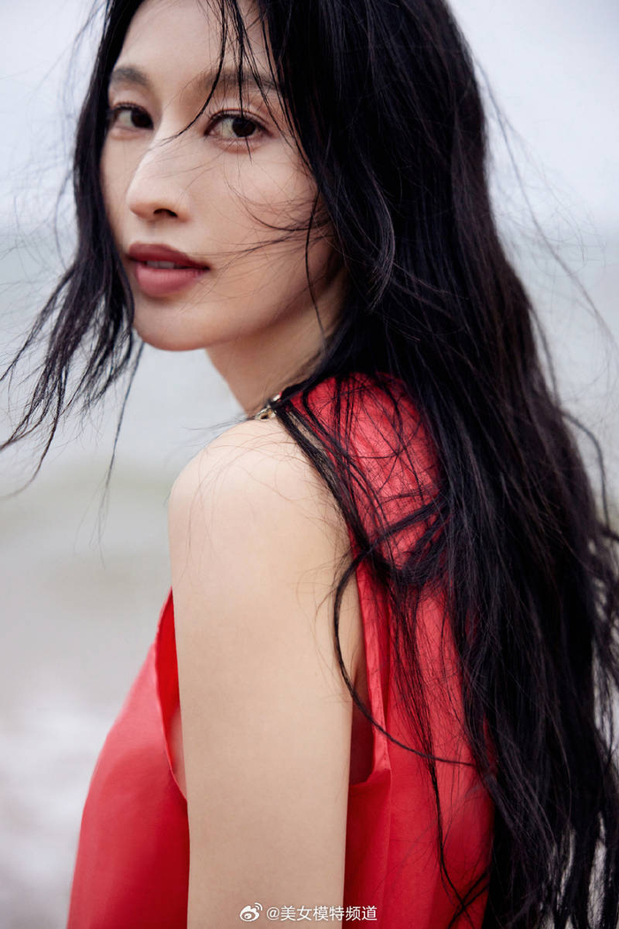 张俪穿红色长裙赤脚漫步海边 海风吹动长发回眸氛围感拉满