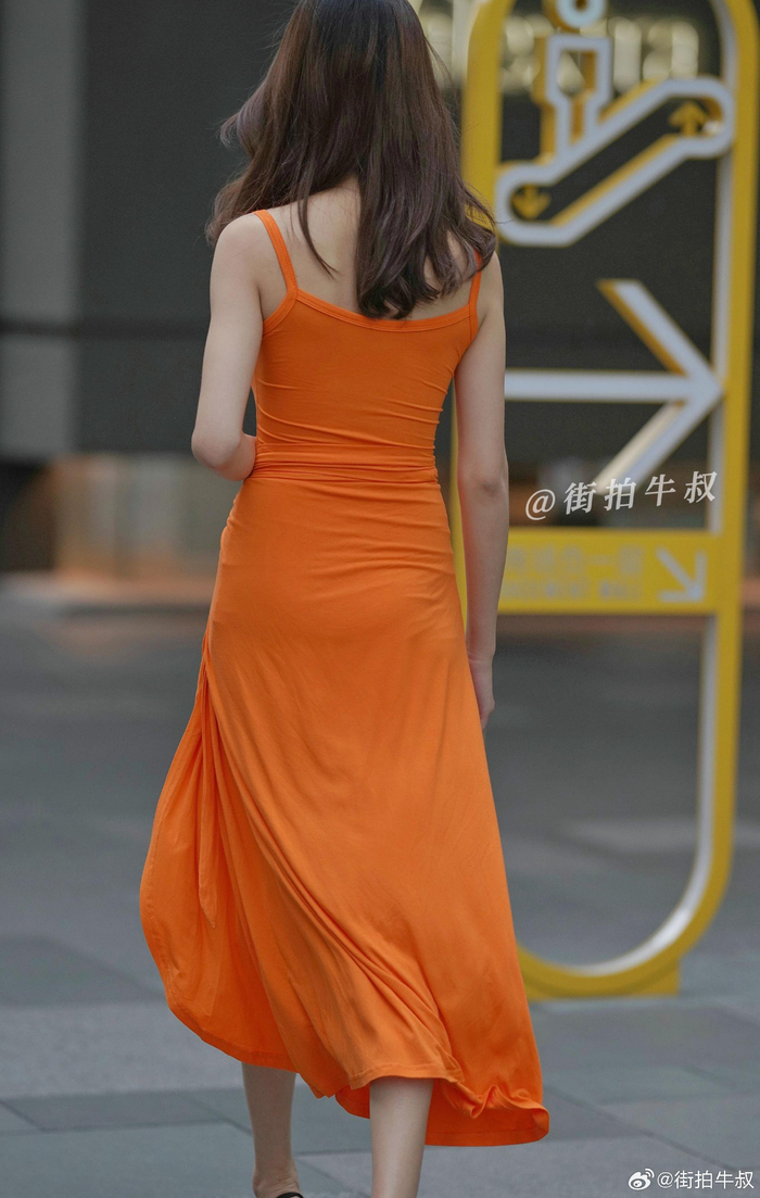 美女穿着性感的桔色开叉长裙出街