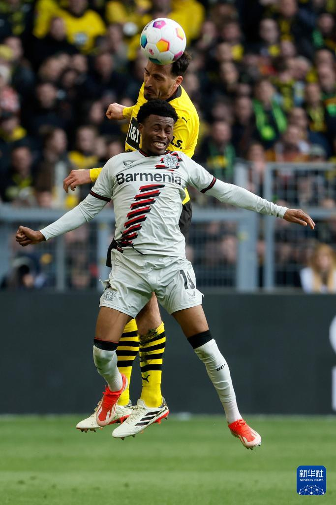 4月21日,多特蒙德队球员胡梅尔斯(后)与勒沃库森队球员泰拉在比赛中