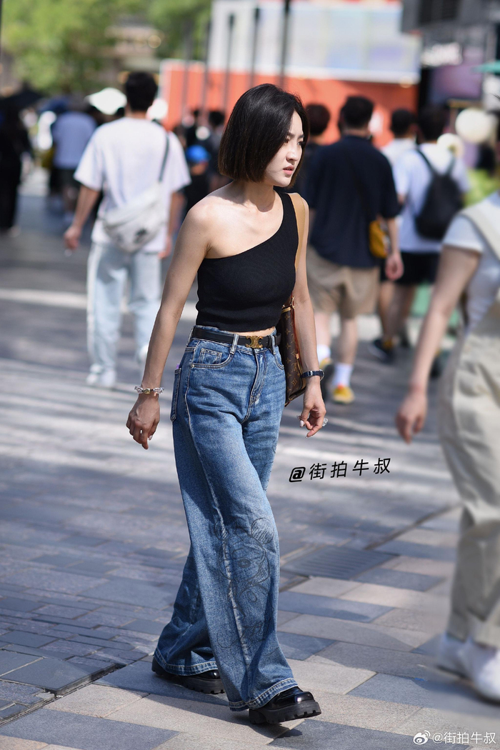 美女穿着时髦的黑色单肩针织衫出街