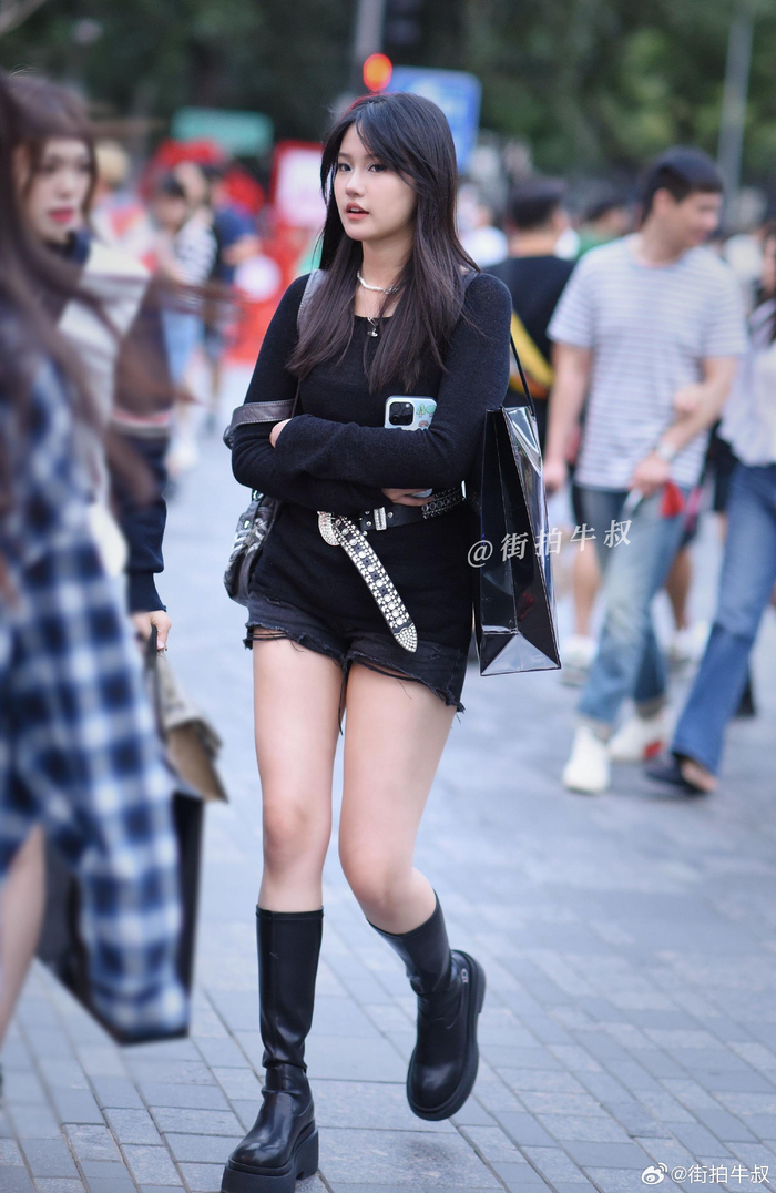 姑娘穿着酷酷的长筒靴出街