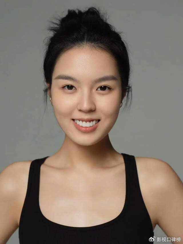 扎着丸子头,简约又大方,气质不错,两排牙齿又白又整齐.