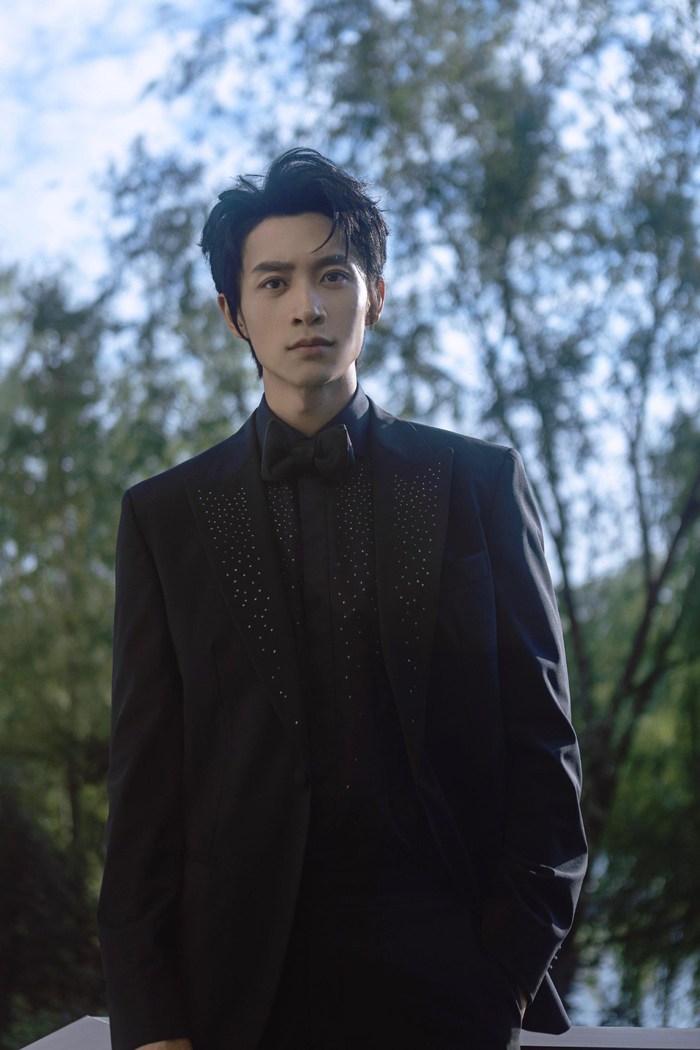 ️眼眸澄澈清隽,黑色西装内敛沉稳,与葱郁之景相映,携热爱前行