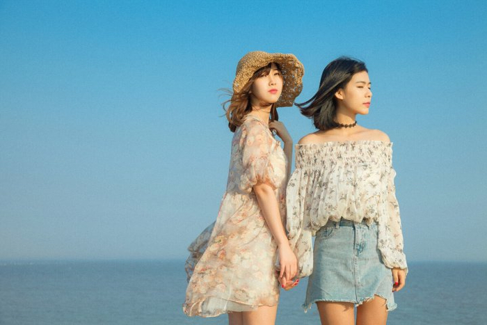 1,看着对方笑想要拍甜甜的闺蜜照片,可以用一些甜甜的拍照姿势来烘托