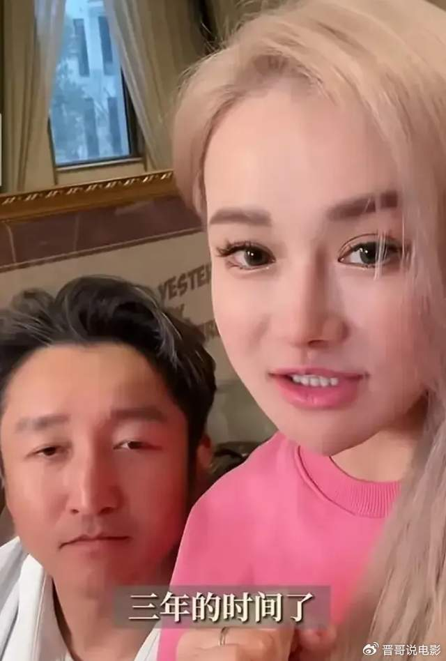 的打扮非常时尚,一头金色长发,精致漂亮的妆容,搭配粉色长袖卫衣,隔着
