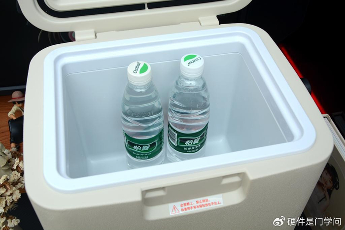 车载冰箱采用立式柜体,手提式设计,边角圆润,上部为乳白色外壳,下部为