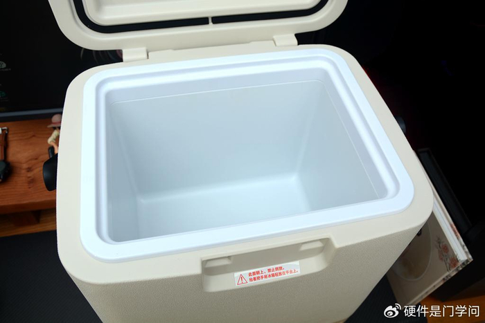 车载冰箱采用立式柜体,手提式设计,边角圆润,上部为乳白色外壳,下部为