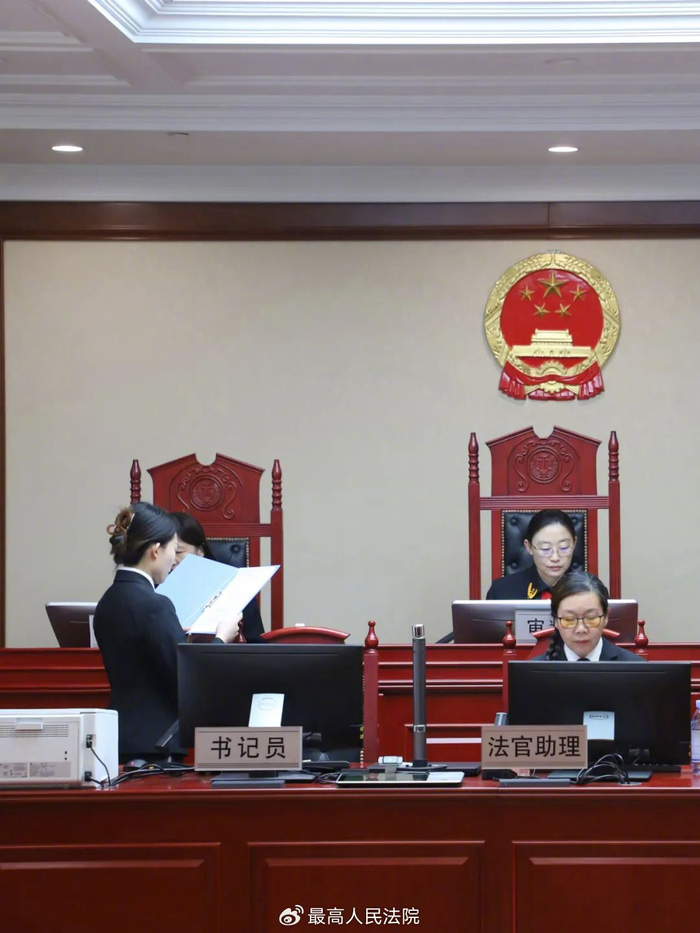 图为书记员向法官汇报开庭准备情况."我这咋听不到啊?