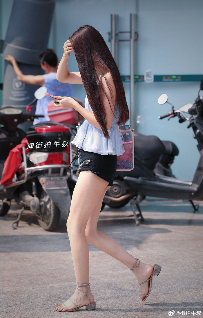 身材高挑的美女穿着时尚的系带热裤出街