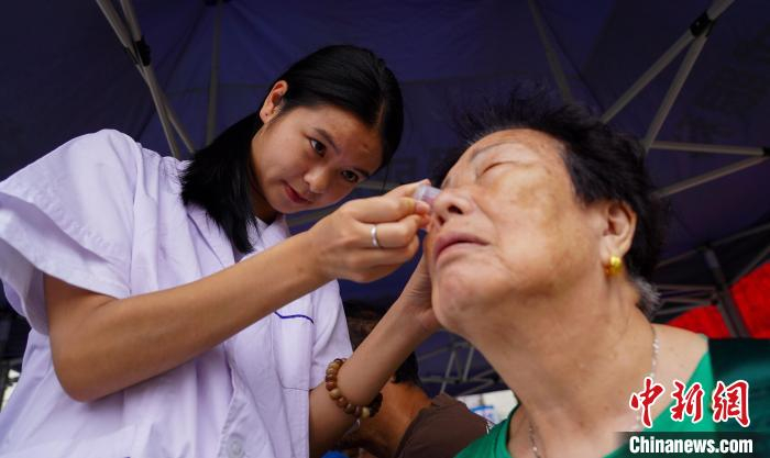 6月6日,医护人员在贵州省从江县丙梅街道免费为老人做眼部护理.