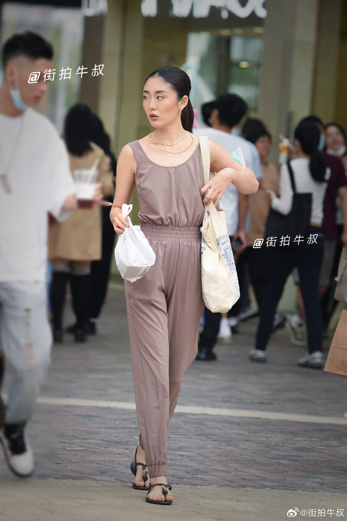 美女穿着好看的松紧腰吊带连体裤出街