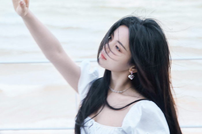 杨超越海边大片一袭白色连衣裙爱心耳环点缀发丝飞扬