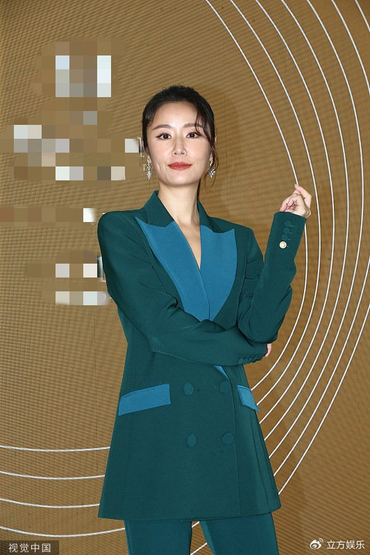 林心如身穿蓝绿色西装出席活动,她朝着镜头挥手微笑,气质优雅有型