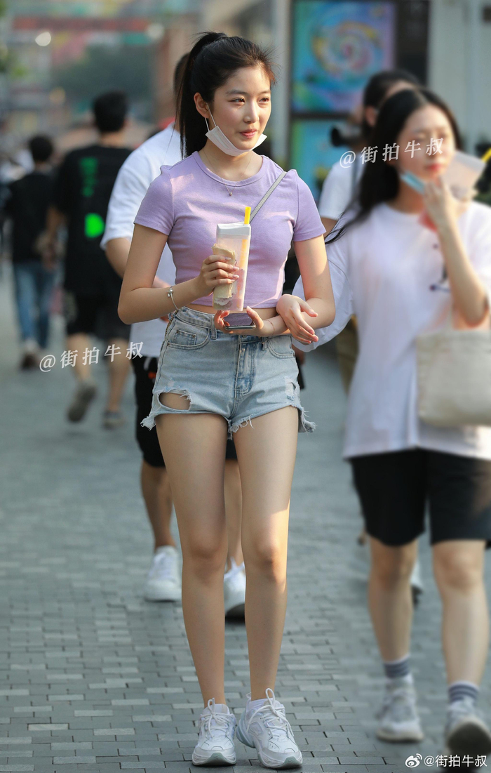 美女穿着甜美的短袖破洞裤出街