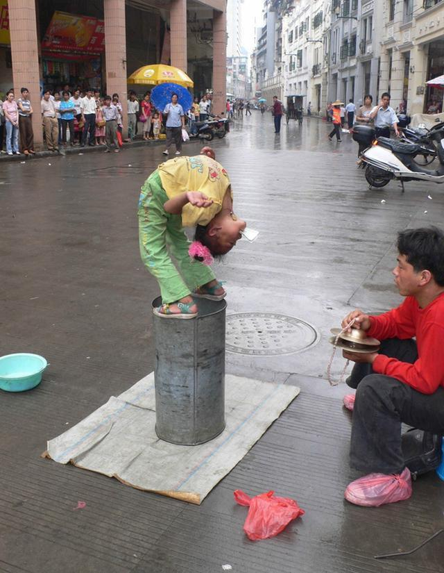 小女孩在街头冒雨卖艺,没想到,等她拿着盆子讨钱时人们却这样做