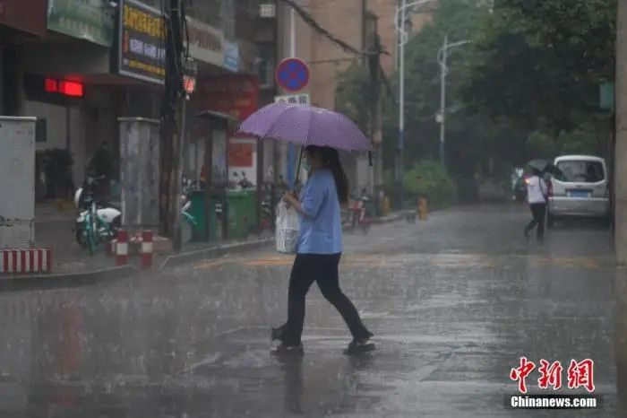 6月18日下午，云南省昆明市突降暴雨，市民冒雨出行。中新社记者 刘冉阳 摄