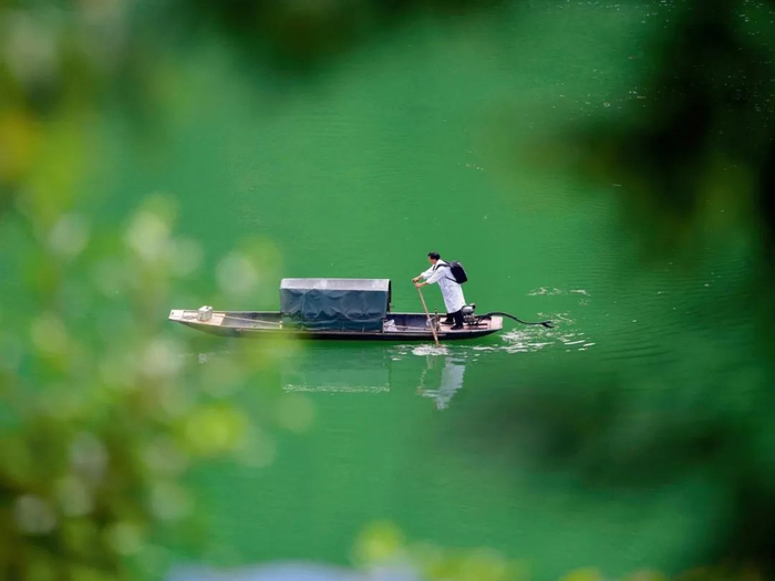 ▲5月27日，贵州省黔东南苗族侗族自治州丹寨县排调镇双尧村村医龙光庆摇着摆渡船行进在双尧村的河道上 杨武魁摄/本刊