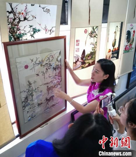 田丽向客人介绍京绣书画作品。　吕子豪 摄