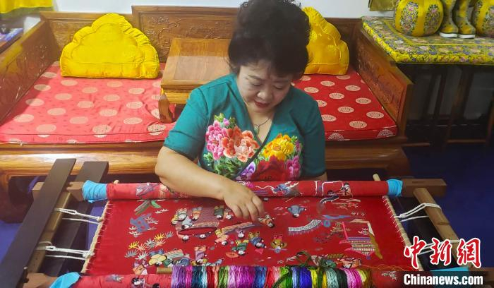 梁淑平在绣制“百子图”。　徐巧明 摄