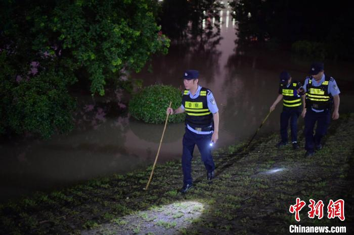 南京建邺区民警连夜巡逻检查被江水的亲水步道周边和四面环江的江心洲大堤。　国武 摄