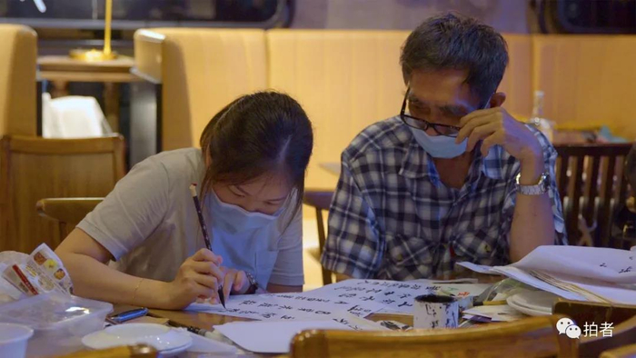  △&nbsp;7月4日，银杏馆餐厅，郑宝航正在教义工写毛笔字。