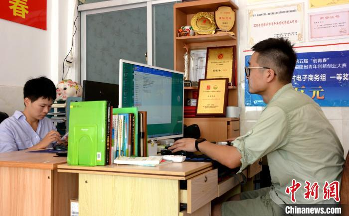 李向锋、陈晓冬夫妻在电脑前处理当天的芭乐电商预售订单。　龚雯 摄