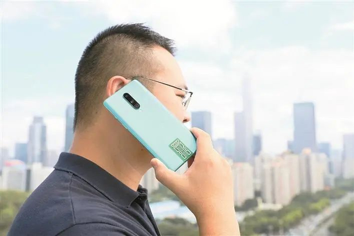 市民陆先生正在测试贴有信号增强贴片手机的通话效果。深圳晚报记者 张焱焱 摄