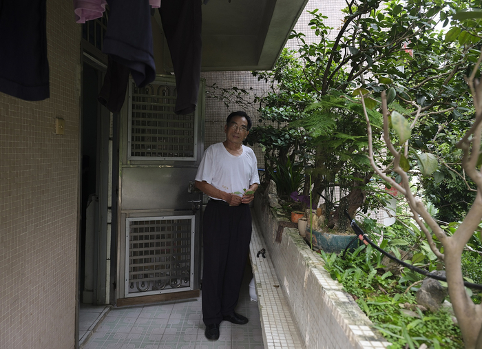 刘永广在阳台上打理盆栽。摄影：翟星理